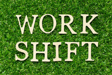 Wood letter in word work shift on green grass background