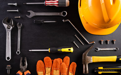 Happy Labor day concept. Different construction tools on black wooden background.