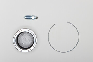 Caliper repair kit, metal piston-plunger, retaining ring and fitting. Set of spare parts for car brake repair. Details on white background, copy space available. UHD 4K.