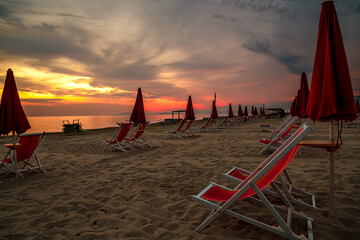 spiaggia al tramonto 01 - spiaggia con ombrelloni rossi con cielo al tramonto