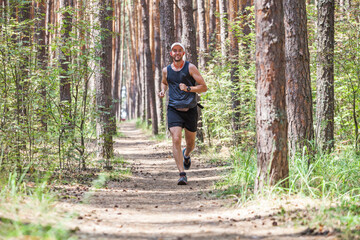 Running man. Jogging working out in the forest