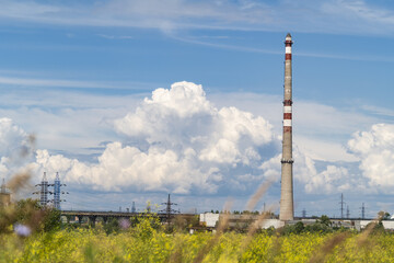 factory chimneys over the blue sky with white clouds