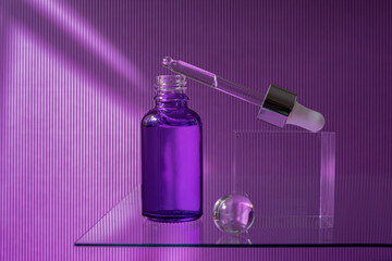 Open purple glass dropper bottle with serum and a pipette. Violet background with daylight....