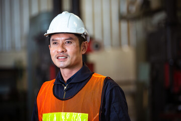 Portrait of Asian man engineer industrial foreman standing at factory. technician worker in safety uniform. Industry technology manufacturing. looking with vision. copy space
