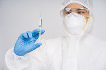 Scientists wear protective clothing while using syringe to test viral drugs in laboratory