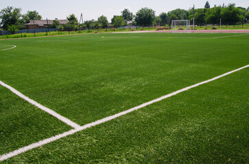Obraz premium A green football field. A field of artificial grass in a school or public park.