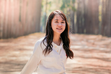 Portrait of  a beautiful teenager girl with long hair in the Park,