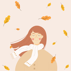 A brown-haired autumn girl with falling leaves in a beige jacket and white scarf