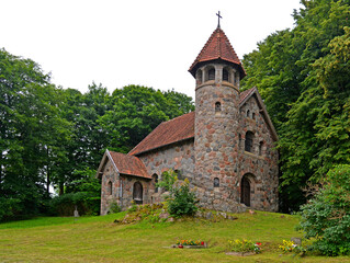 Fototapeta na wymiar Built in 1925 from field stone, the Neo-Romanesque Evangelical-Ausburg church in Rasząg na warmi in Poland.
