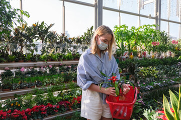 Fototapeta premium shopping in plant gardening shop mask girl pick flowers for garden shopping real, home gardening, eco, eco friendly,Our Life Offline.