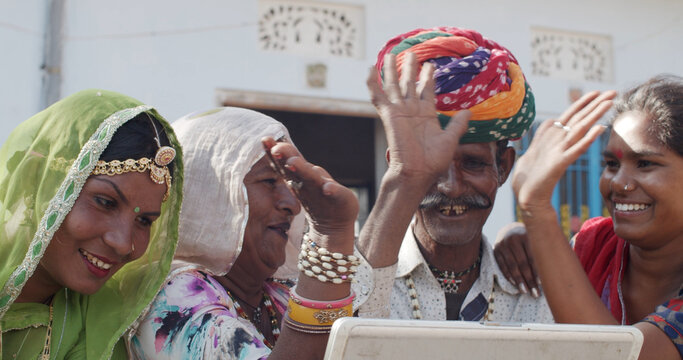 Group Of South Asian People In Traditional Indian Clothing Video Calling On A Laptop