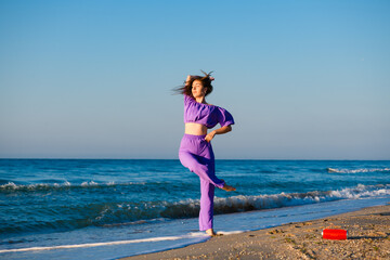 Girl dance at beach with bluetooth speaker