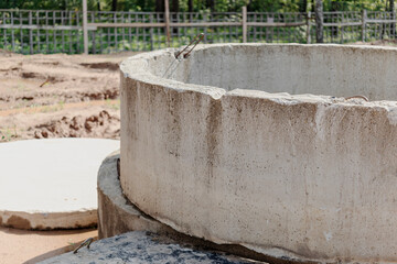 Installation of concrete sewer wells in the ground at the construction site. The use of reinforced...