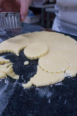 cookie cutters cutting out sugar cookies with cookie dough.