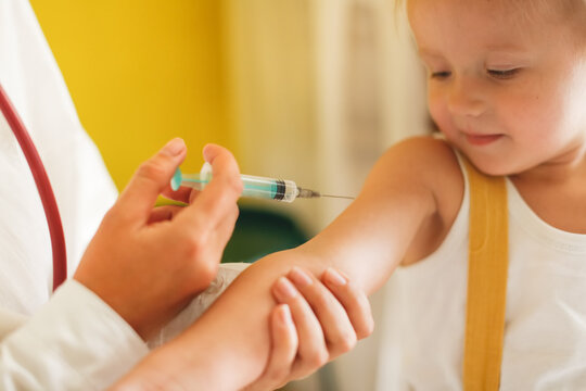 A nurse doctor makes an injection to a child's baby at home in a bedroom, an examination of a baby at home, a patronage. Regular medical examination of babies, preventive vaccinations