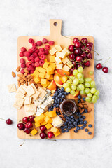 Summer cheese board with season berries, top down view
