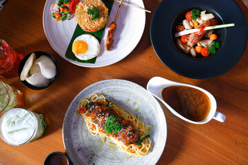Chicken fried rice, spaghetti honey-glazed duck breast and tom yum goong with a drink on a table. top view food photography