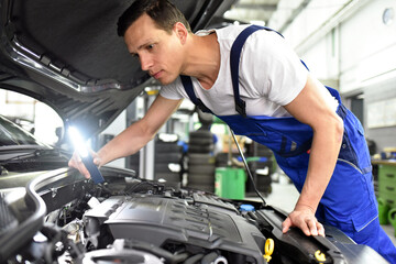Fototapeta na wymiar car mechanic in a workshop repairing a vehicle