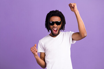 Portrait of attractive cheerful lucky guy rejoicing having fun isolated over bright violet purple color background