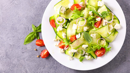 zucchini slices salad with garlic, tomato and feta cheese