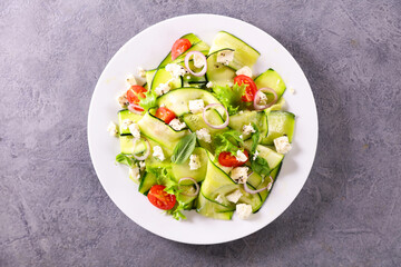 zucchini slices salad with garlic, tomato and feta cheese