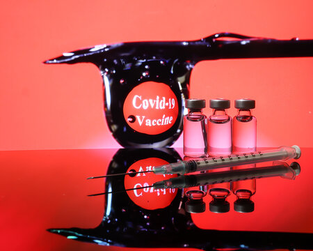 Small vaccine injection bottle transparent reflection refraction red led light background hypodermic syringe needle droplet type covid 19 vaccine