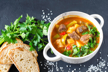 Traditional hungarian goulash with meat and vegetables on the black background