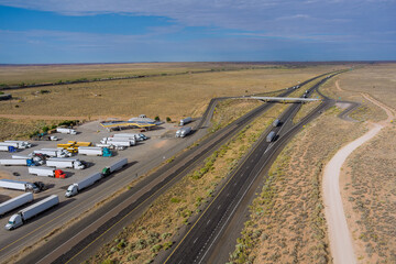 Horizontal panorama trucks stop on rest area near Interstate highway in desert Arizona