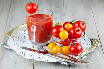Tomatoes, tomato ketchup and tomato juice with lettuce leaves, isolated on a green background.