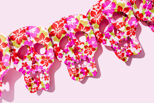 Studio shot of row of red skull masks decorated with floral patterns