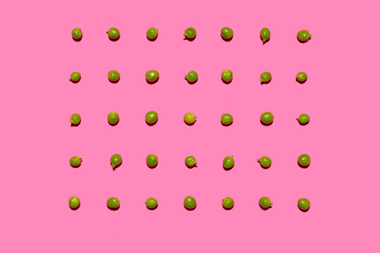 Studio shot of green peas flat laid against pink background