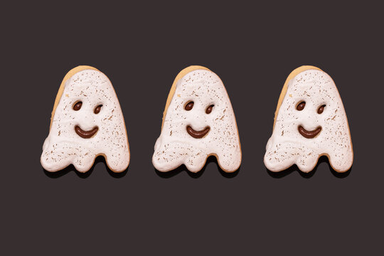 Studio shot of three glazed ghost-shaped chocolate cookies