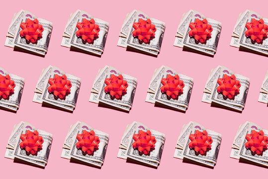 Pattern of rows of folded dollar bills with red gift bows