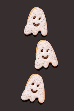 Studio shot of three glazed ghost-shaped chocolate cookies