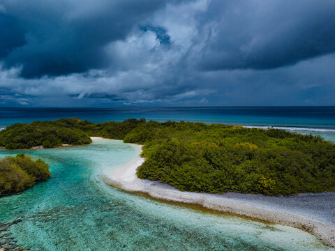 Trees on island under cloudy sky at Thulusdhoo Island, Kaafu atoll, Maldives