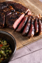 Medium-rare rib eye steak with vegetable sauce.