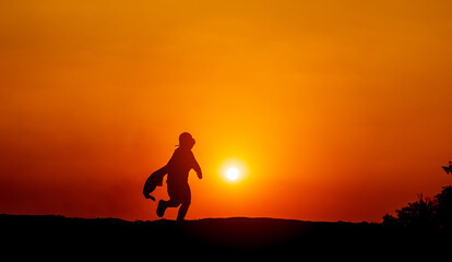 The silhouette of a superhero rushes forward with determination and determination. jogging with sun in the background, silhouette concept and evening running