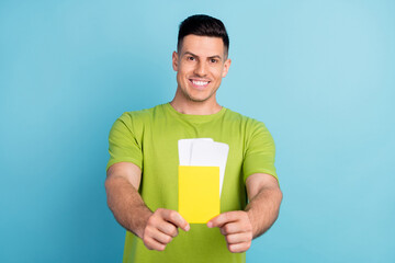 Photo of positive happy cheerful man hold hands tickets passport give young isolated on green color background