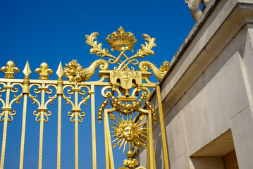 Close-up of golden fence with beautiful ornaments at the entrance of Palace of Versailles on a...