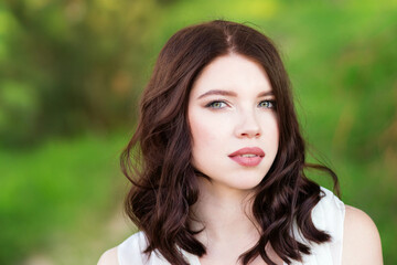 Naklejka premium Close Up Portrait Romantic Young Woman in Summer Park. Pretty Girl Looking at Camera Enjoying Good Weather. Free Happy Girl.