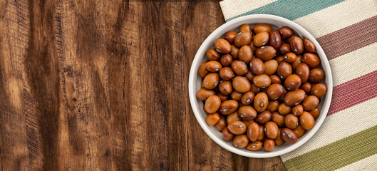 Obraz na płótnie Canvas Beans in a Ceramic Bowl. These nutritious legumes are high in protein and fiber. The image is a cut out, isolated on a wood background