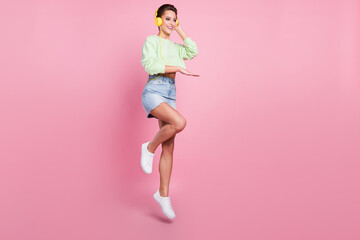 Full size profile side photo of young girl happy positive smile music dj earphones jump isolated...