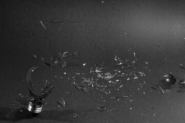 glass light bulb breaking on a black background