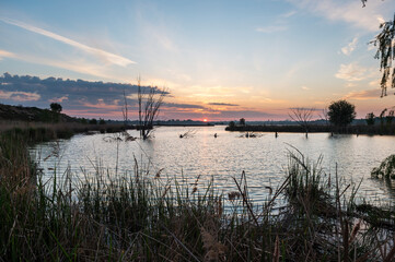 estanque de agua natural con la salida del sol al fondo