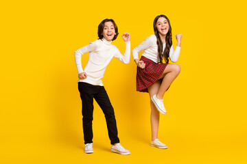 Full length body size photo of children dancing happy won lottery isolated bright yellow color background