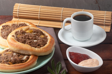 Meat esfiha with a black coffee.