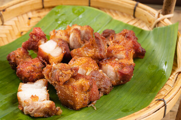 Deep fried pork belly with fish sauce placed on a banana leaf.