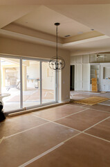 View of large empty room under construction, with large glass doors