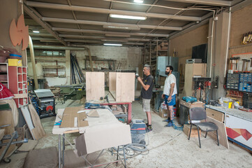 Two carpenters making furniture in a workshop. Woodworking and crafts tools