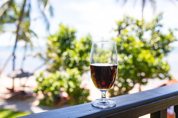 glass of red wine served on outdoor terrace with beautiful romantic  beach and sea view